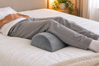 Coussin demi-lune sous les jambes, au lit