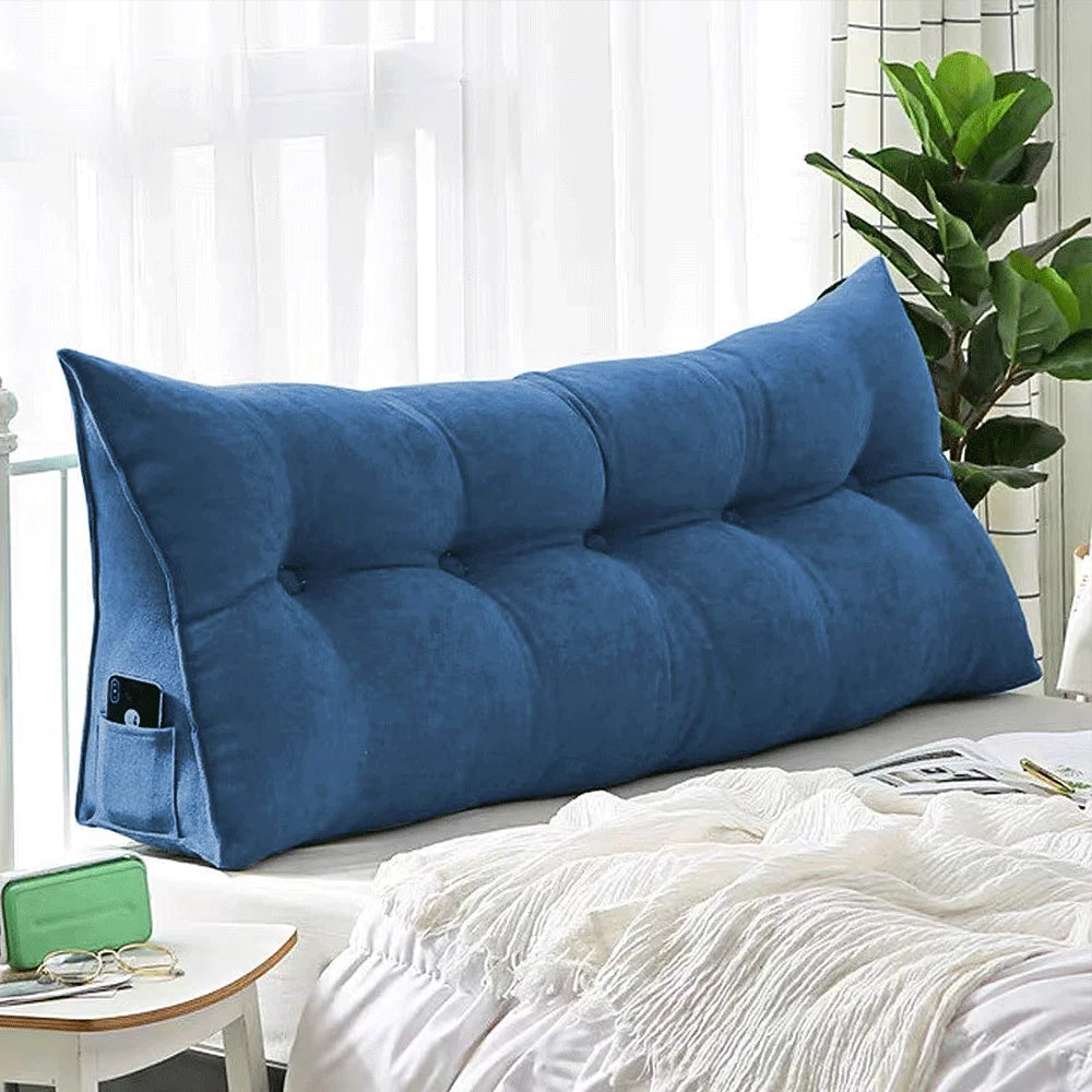 Coussin de dossier long bleu, tissu lisse, contre une tête de lit