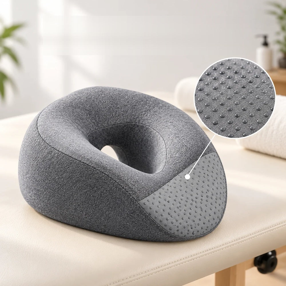 Coussin facial en mousse à mémoire de forme posé sur une table de massage, dessous antidérapant